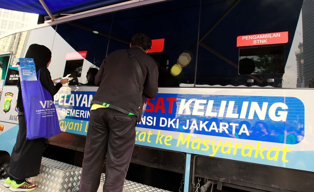Warga memanfaatkan keberadaan bus pelayanan Samsat Keliling Provinsi DKI Jakarta yang hadir di kawasan hari bebas kendaraan bermotor, Bundaran Hotel Indonesia, Jakarta, Minggu (22/9/2019).