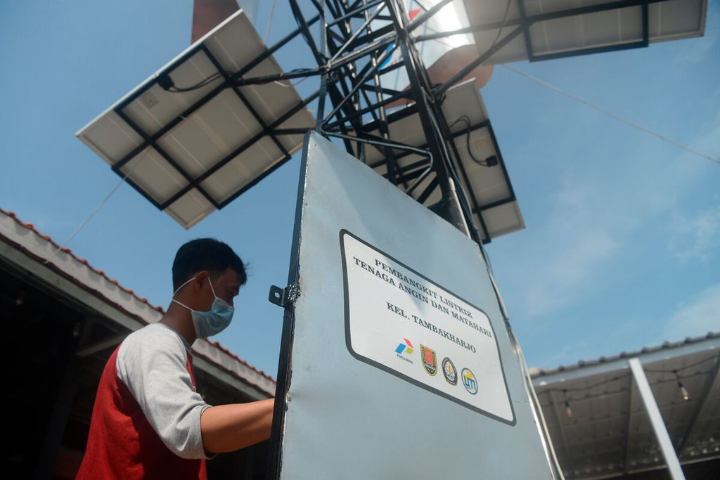 Warga memeriksa dan melakukan perawatan rutin pada instalasi panel surya dan kincir angin untuk pembangkit listrik di Taman Kuliner Tambakharjo, Kota Semarang, Jawa Tengah, Jumat (4/3/2021). Mereka mulai memanfaatkan dan dikenalkan pada energi terbarukan yang ramah lingkungan untuk kebutuhan warung.