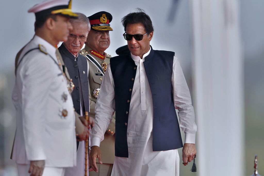 Perdana Menteri Pakistan Imran Khan (kanan) tiba untuk menghadiri acara parade militer dalam memperingati Hari Nasional Pakistan di Islamabad, Pakistan, 23 Maret 2022. Tampak Panglima Militer Pakistan Jenderal Qamar Javed Bajwa (ketiga dari kiri) juga hadir di acara tersebut. 
