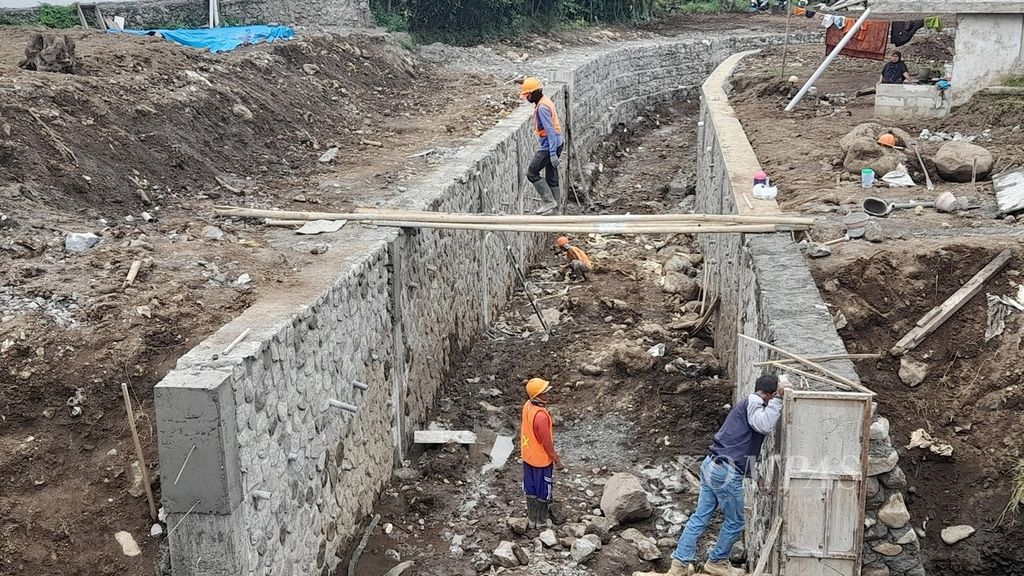 Pekerja menyelesaikan pelebaran Kali Sambong ke daerah hilir di Dusun Gintung, Desa Bulukerto, Kecamatan Bumiaji, Kota Batu, Jawa Timur, yang menjadi titik terdampak banjir bandang, Kamis (3/3/2022). Tujuh warga menjadi korban jiwa bencana banjir bandang yang terjadi pada November 2021 itu.