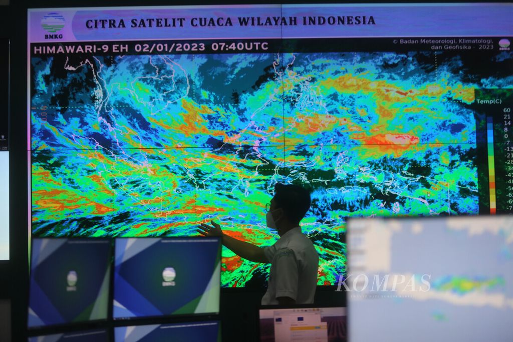 Anggota staf bagian Meteorology Early Warning Center di Badan Meteorologi, Klimatologi, dan Geofisika (BMKG), Jakarta, memonitor citra liputan awan, arah dan kecepatan angin, serta sistem prakiraan kondisi kelautan, Senin (2/1/2023). 