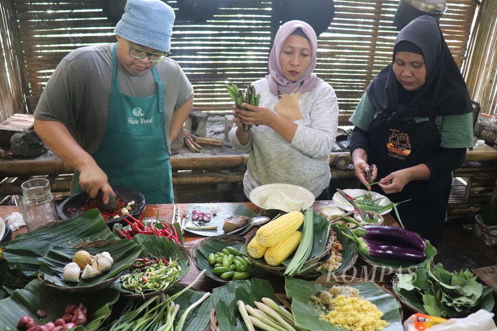 Chef Ragil Imam Wibowo (kiri) bersama anggota Komunitas Cengkeh Afo dan Rempah Gamala meracik rempah dan bahan makanan untuk dimasak menjadi makanan tradisional di Kelurahan Tongole, Kecamatan Ternate Tengah, Kota Ternate, Maluku Utara, Selasa (29/3/2022).