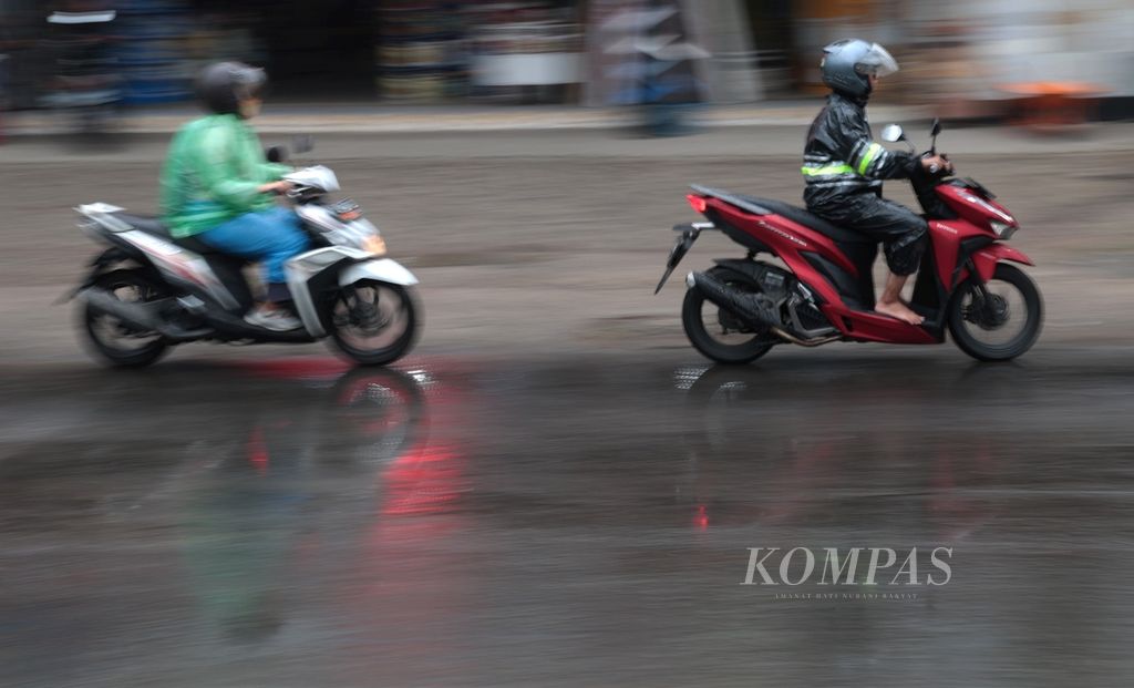 Pengendara motor menggunakan jas hujan saat hujan mengguyur kawasan Meruyung, Depok, Jawa Barat, Sabtu (4/11/2023). Badan Meteorologi, Klimatologi, dan Geofisika (BMKG) melaporkan, saat ini sejumlah daerah di Indonesia telah memasuki masa peralihan dari musim kemarau ke musim hujan.