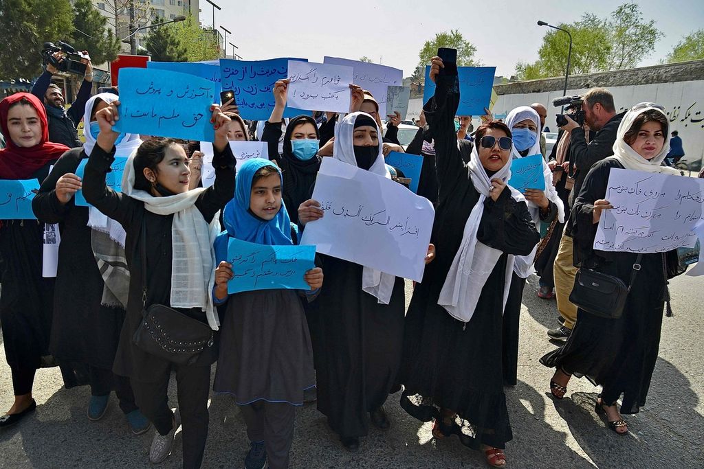 Anak-anak dan remaja perempuan Afghanistan berunjuk-rasa di depan Kementerian Pendidikan di Kabul, Afghanistan, 26 Maret 2022. Mereka menuntut agar sekolah kembali dibuka untuk perempuan. (Photo by Ahmad SAHEL ARMAN / AFP)