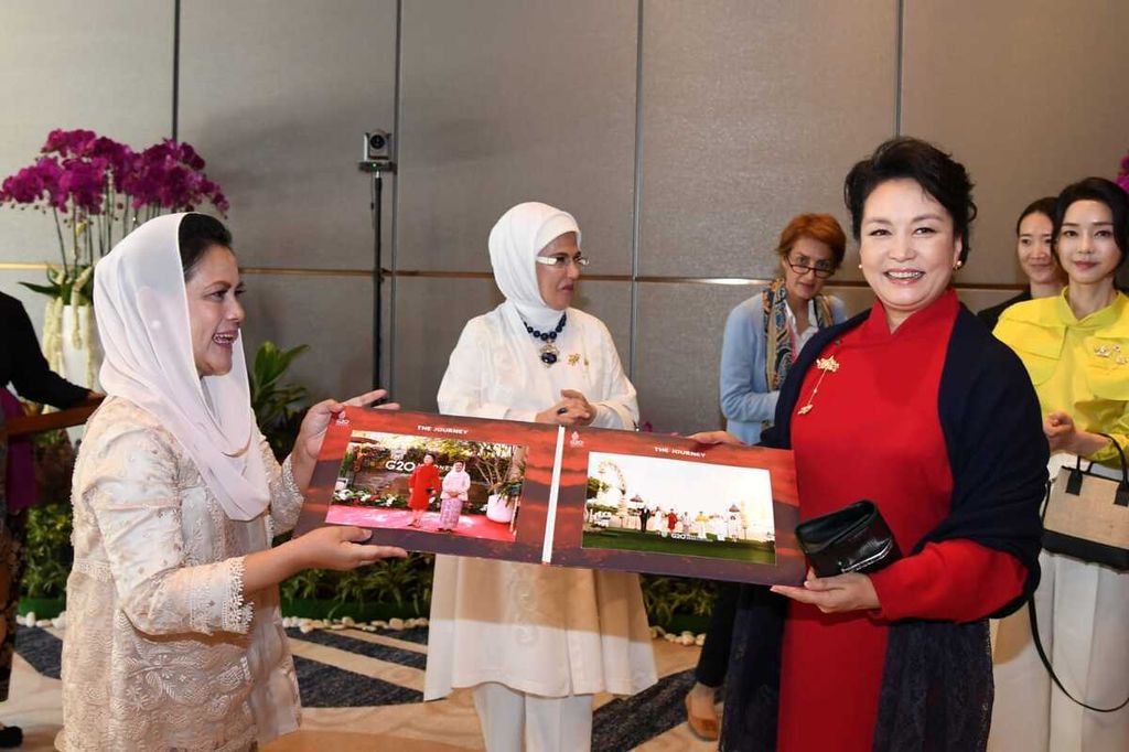 Ibu Negara Iriana Joko Widodo saat menyerahkan album foto kepada para pendamping pemimpin negara-negara G20 dan lembaga internasional sebagai kenang-kenangan di Sofitel Bali Nusa Dua Beach Resort, Selasa (15/11/2022).