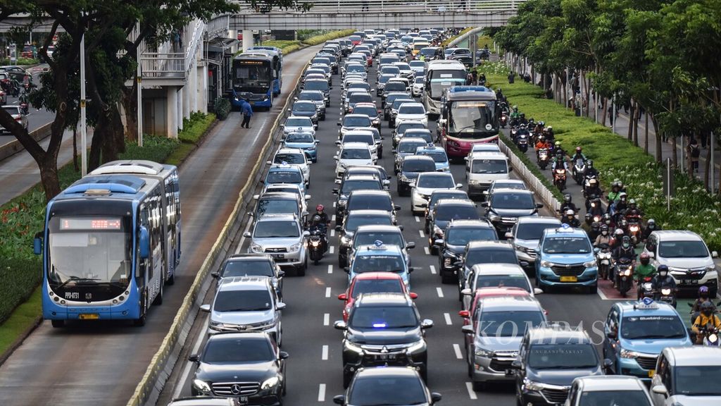 Bus Transjakarta melintasi kendaraan yang terjebak kemacetan di Jalan Jenderal Sudirman, Jakarta Pusat, Senin (13/12/2021). 
