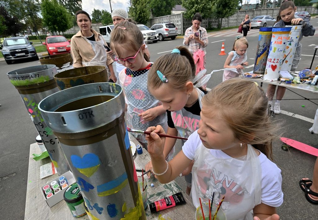 Anak-anak Ukraina sedang melukis di penampang selongsong peluru di Museum Memori, Bucha, Kyiv, pada 30 Juni 2023.