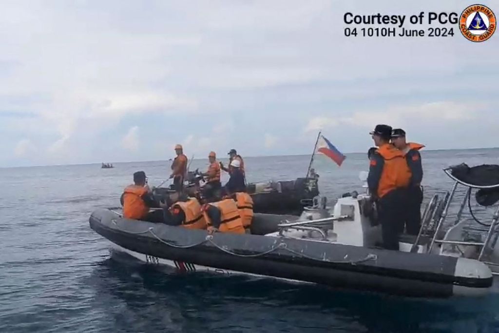 Foto selebaran yang dicuplik dari video dan dirilis Penjaga Pantai Filipina pada 7 Juni 2024 ini menunjukkan personel Penjaga Pantai China menghalangi kapal Filipina yang membawa ilmuwan kelautan di Laut China Selatan. 