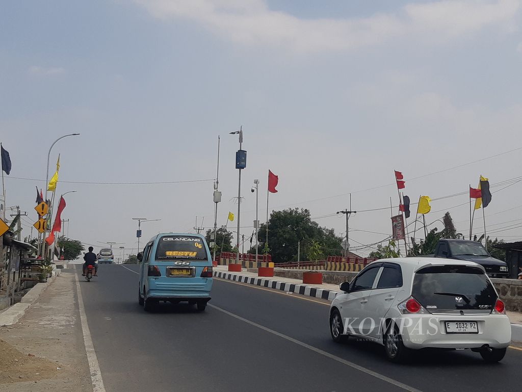 Sejumlah bendera berwarna merah, hitam, dan kuning berkibar di sepanjang jalan raya wilayah Kecamatan Kapetakan, Kabupaten Cirebon, Jawa Barat, Senin (18/9/2023). Bendera itu menjadi penanda pendukung calon kuwu atau kepala desa setempat.
