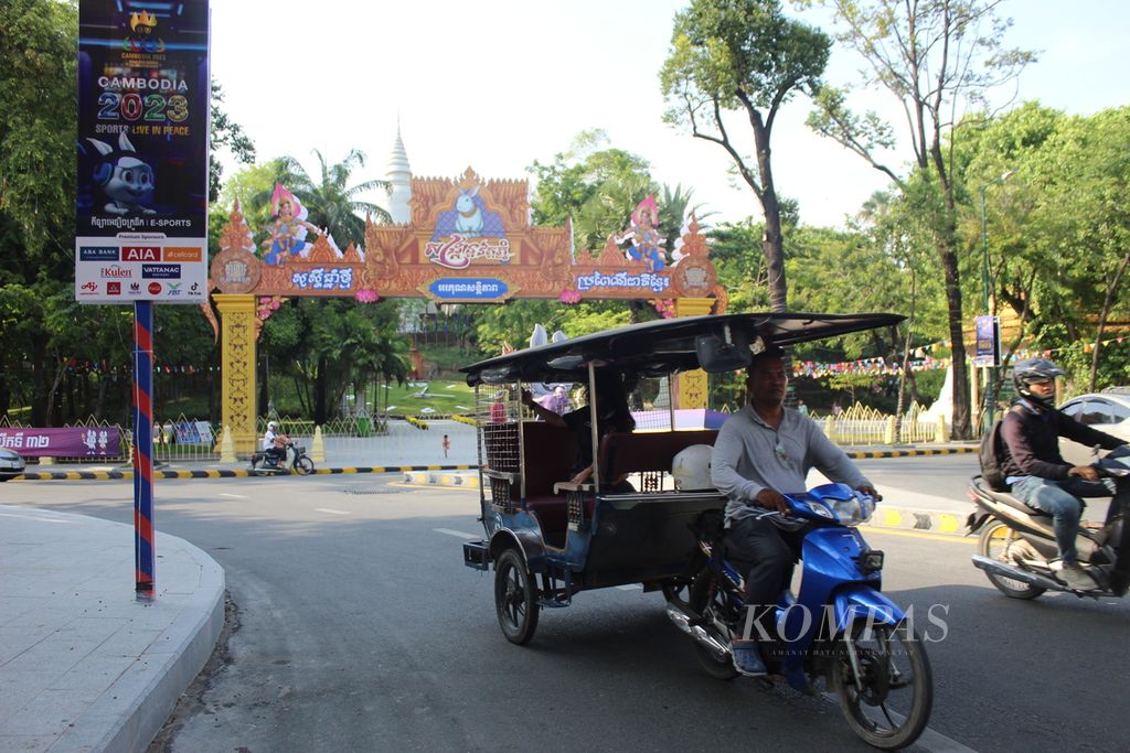 Tuktuk melintas di depan Wat Phnom, salah satu obyek wisata di kota Phnom Penh, Kamboja, Selasa (2/5/2023). Tuktuk mulai dibanjiri penumpang jelang SEA Games Kamboja 2023. Di banyak sudut ibu kota Kamboja tersebut, kemeriahan SEA Games mulai terasa.