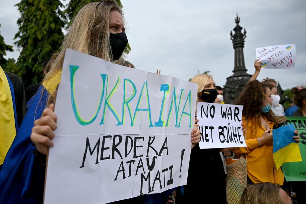 Warga membentangkan poster dalam unjuk rasa terkait krisis Ukraina di Monumen Bajra Sandhi, Denpasar, Bali, 1 Maret 2022. 