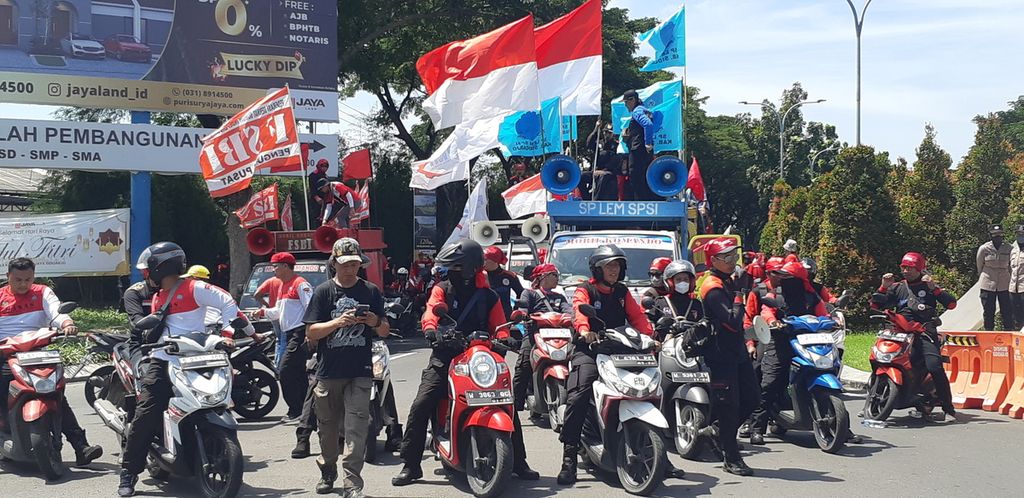 Dengan menggunakan truk dan mobil komando, buruh di Sidoarjo berunjuk rasa memperingati Hari Buruh pada Rabu (1/5/2024) di Puri Surya Jaya. 