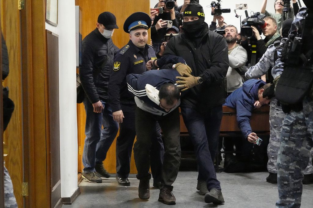 Saidakrami Murodali Rachabalizoda, tersangka penembakan di Balai Kota Crocus, dikawal polisi dan petugas FSB di Pengadilan Distrik Basmanny di Moskwa, Rusia, pada 24 Maret 2024. 