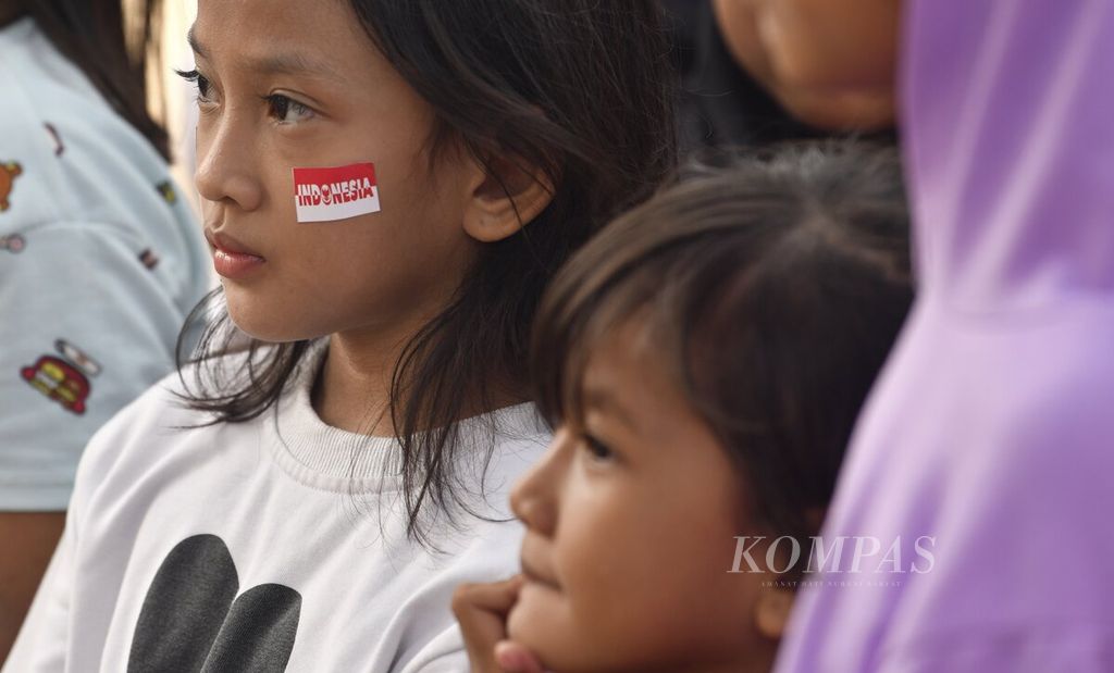 Stiker bertuliskan Indonesia terpasang pada pipi salah satu anak yang mengikuti perlombaan dalam rangka peringatan HUT Kemerdekaan RI di Jalan Lingkar Luar Barat, Cengkareng, Jakarta Barat, Kamis (17/8/2023). 