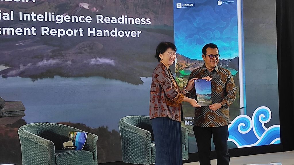 (Dari kiri ke kanan) Direktur dan Perwakilan Kantor Regional UNESCO di Indonesia Maki-Katsuno-Hayashikawa dan Wamenkominfo Nezar Patria berfoto bersama sambil memegang laporan penelitian kesiapan AI di Indonesia, Jumat (4/10/2024), di Jakarta.