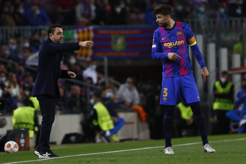 Pelatih Barcelona Xavi Hernandez (kiri) memberikan instruksi kepada bek Barcelona Gerard Pique saat melawan Napoli dalam putaran pertama babak fase gugur Liga Europa di Stadion Camp Nou, Barcelona, Spanyol, Jumat (18/2/2022) dini hari WIB. Pique menjadi titik terlemah Barca di lini pertahanan.