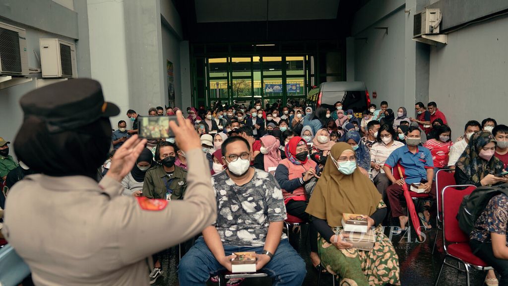  Police take pictures of the queues of residents who will get vaccinated at the precision vaccine booth at Patriot Candrabhaga Stadium, Bekasi City, West Java, Tuesday (8/2/2022).