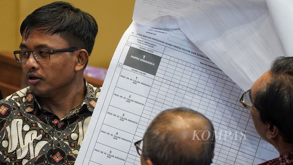 Anggota Komisi Pemilihan Umum, Idham Holik, menunjukkan contoh lembar rekapitulasi suara pemilu saat rapat dengar pendapat (RDP) antara Komisi II DPR dan KPU di Ruang Sidang Komisi II DPR RI, Jakarta, Senin (29/5/2023). 
