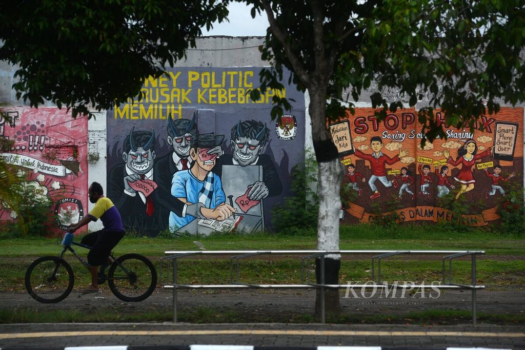 Warga melintas di depan mural tentang Pilkada di Stadion Kridosono, Kotabaru, Yogyakarta, Rabu (21/10/2020). Mural membantu gaung sosialisasi Pilkada untuk membantu masyarakat menyikapi ajang pesta demokrasi tersebut secara positif.