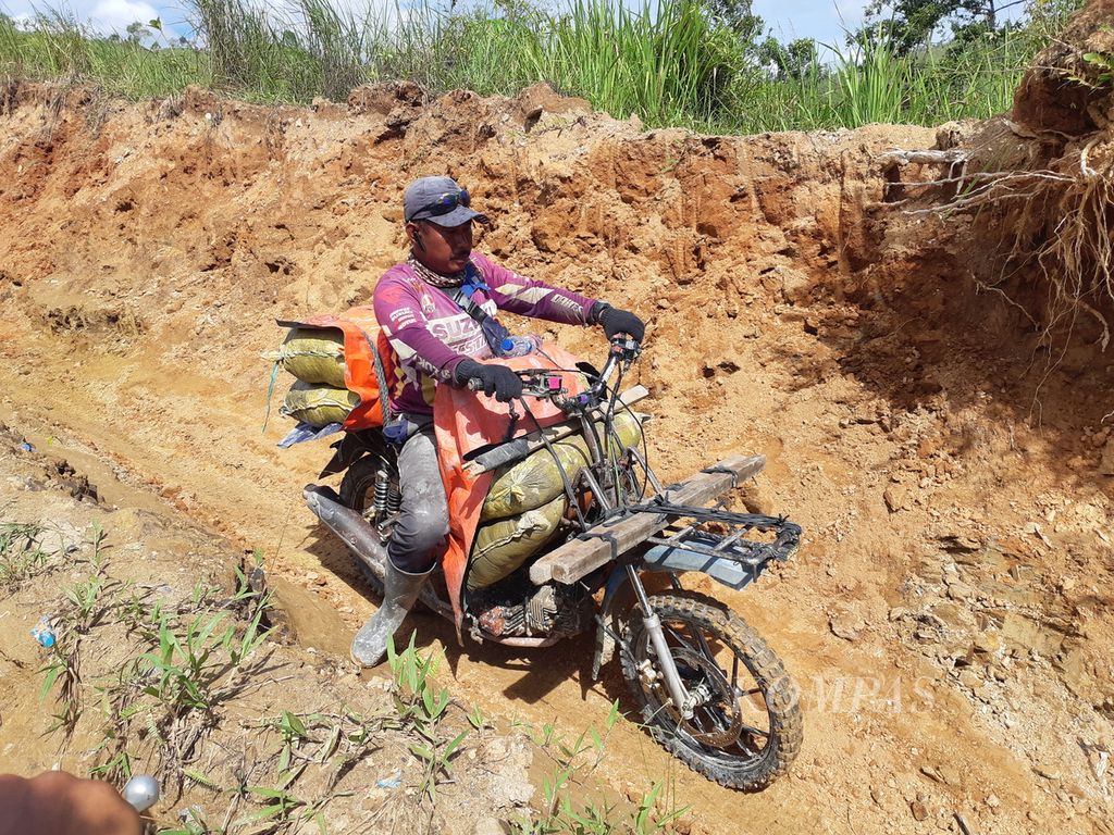 Motorcycle drivers carrying materials passed a dirt road inside a wildlife reserve in Gunung Botak, Buru Island, Maluku, on Tuesday (20/6/2023). One motorcycle can carry loads of up to 300 kilograms of mining materials.