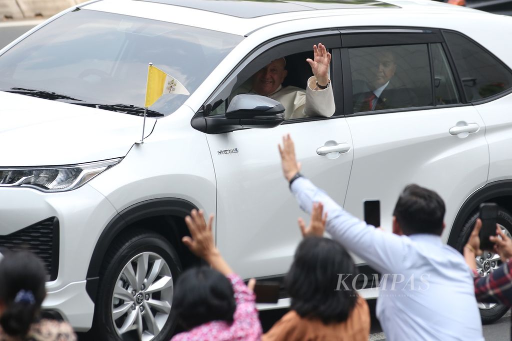 Paus Fransiskus menyapa umat saat bersama rombongan melalui Jalan Sudirman menuju Kedutaan Besar Takhta Suci Vatikan di kawasan Gambir, Jakarta, Selasa (3/9/2024). Paus melakukan perjalanan apostolik di Indonesia hingga Jumat (6/9/3024).