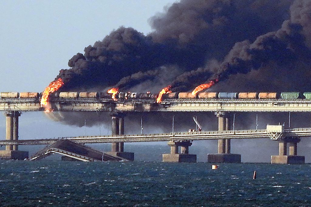 Asap membumbung dari jembata Kerch yang meledak sebagian pada 8 Oktober 2022. Peledakan jembatan itu salah satu sabotase yang mewarnai perang Rusia-Ukraina. 