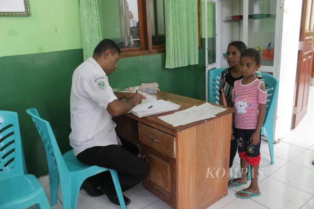 Seorang petugas kesehatan (kiri) sedang mengecek identitas pasien anak yang digigit anjing sebelum diberi vaksin antirabies (VAR) di Puskesmas Beru, Kabupaten Sikka, Flores, Nusa Tenggara Timur, Selasa (4/9/2018).
