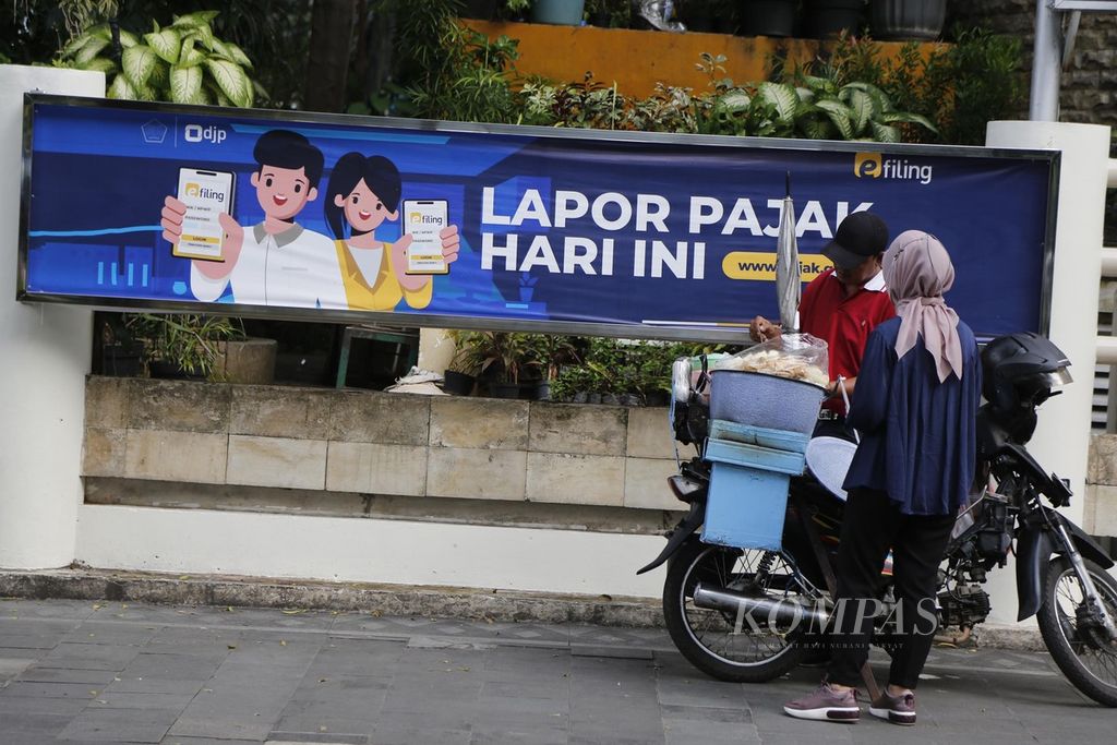 Sosialisasi agar wajib pajak melaporkan pajaknya terpasang di trotoar Jalan Sudirman, Jakarta Selatan, Selasa (21/2/2023).