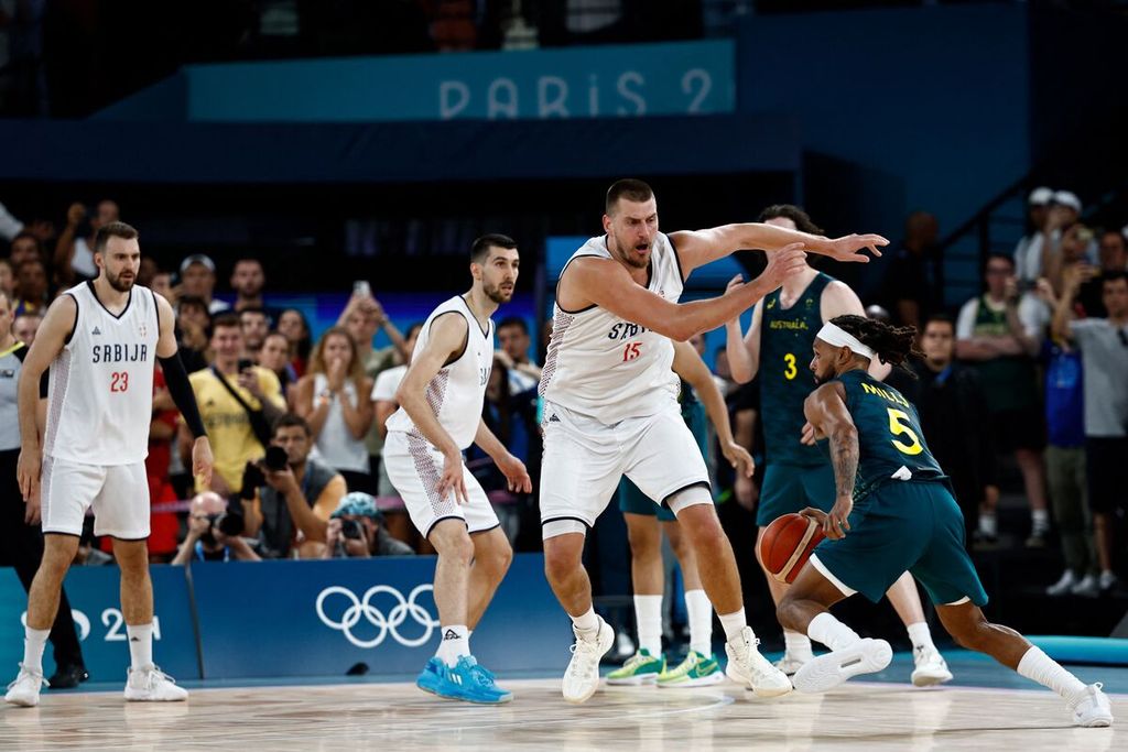 Pemain tim basket Australia, Patty Mills, mencoba melewati hadangan mega bintang tim Serbia, Nikola Jokic, dalam laga perempat final Olimpiade Paris pada Rabu (7/8/2024) dini hari WIB di Bercy Arena, Paris. Serbia menang atas Australia 95-90 pada laga ini.