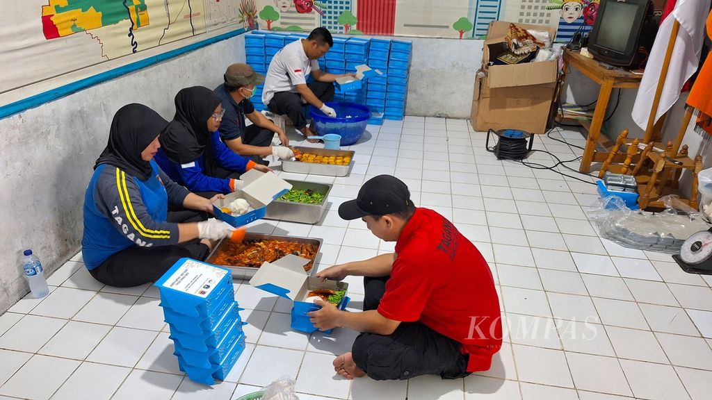 Sukarelawan Tagana mengemas makan siang bagi pengungsi korban kebakaran di dapur umum Posko Tagana Jakarta Barat, Jakarta, Rabu (8/5/2024).