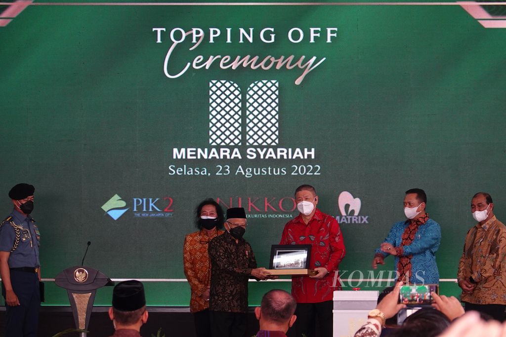 Wakil Presiden Ma’ruf Amin menerima kenang-kenangan seusai meresmikan <i>topping off</i> atau pemasangan atap bangunan sebagai tanda berakhirnya proses konstruksi Menara Syariah di kawasan Pantai Indah Kapuk II, Kabupaten Tangerang, Banten, Selasa (23/8/2022).