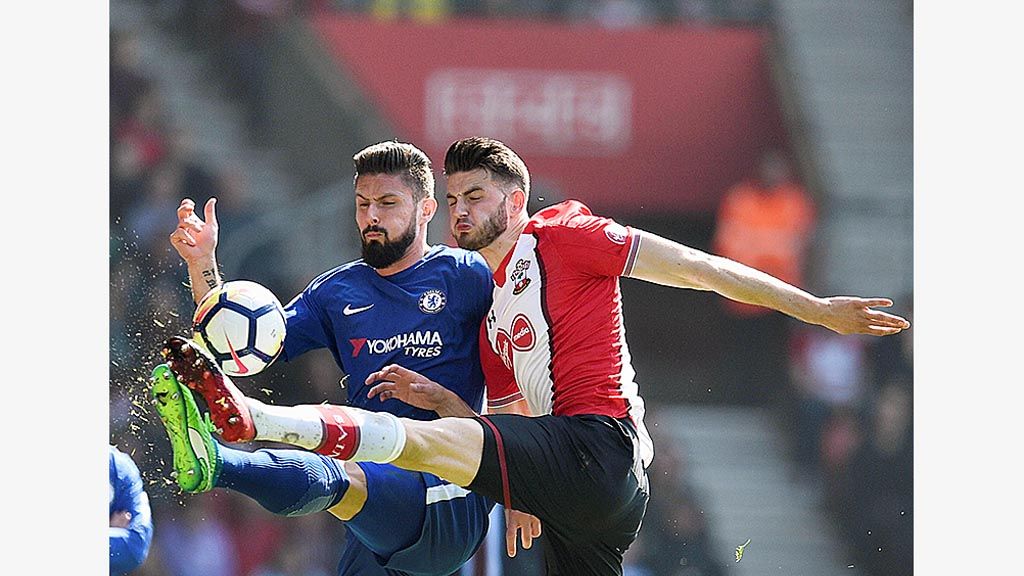 Striker Chelsea, Olivier Giroud (kiri), berebut bola dengan bek Southampton, Wesley Hoedt, pada laga Liga Inggris di Stadion St Mary\'s, Sabtu (14/4/2018). Giroud menginspirasi kemenangan 3-2 Chelsea dengan mencetak dua gol. Chelsea menjaga peluang finis di empat besar.