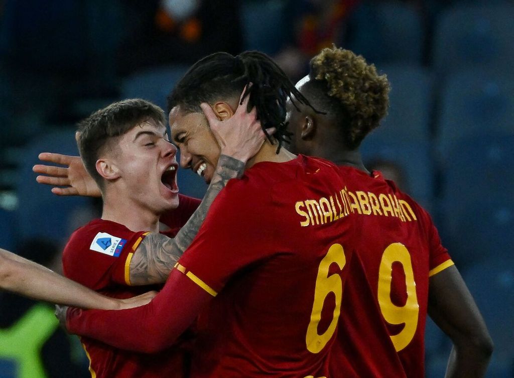 Bek AS Roma, Chris Smalling (tengah), dipeluk rekan-rekannya seusai mencetak gol penentu kemenangan timnya atas Salernitana pada laga Liga Italia di Stadion Olimpico, Roma, Minggu (10/4/2022) tengah malam WIB. Roma menang 2-1 setelah tertinggal 0-1 lebih dulu.