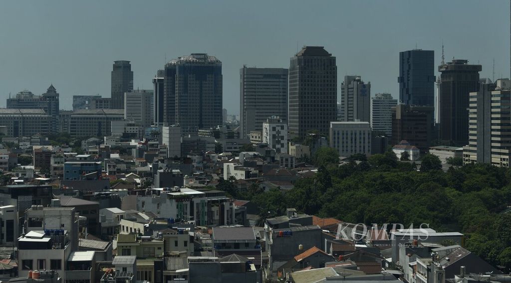 Kawasan permukiman dengan latar belakang gedung-gedung perkantoran di Jakarta, Kamis (16/9/2021). 