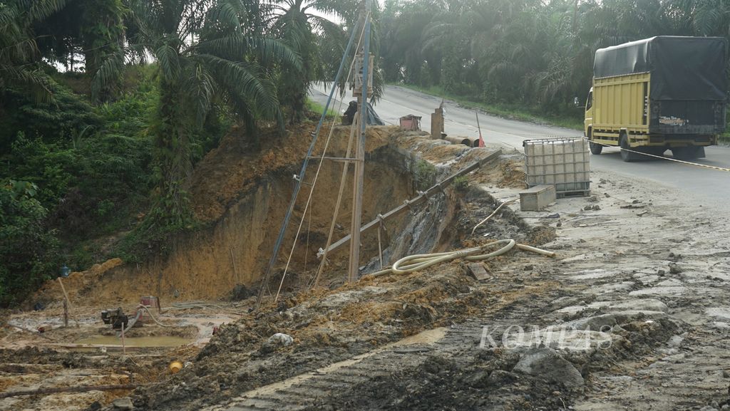 Sebuah truk melewati jalan lintas timur Sumatera di Kabupaten Indragiri Hilir, Riau, Senin (2/1/2022). Jalan ini menjadi jalur penghubung antarprovinsi di Sumatera. Hanya, beberapa kendala ditemui, seperti jalan rusak, bergelombang, serta longsor di sejumlah sisi.