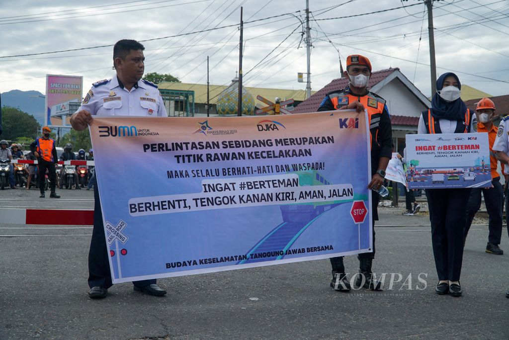Petugas membentangkan spanduk dan poster imbauan kepada warga dalam kampanye keselamatan dalam rangka Hari Perhubungan Nasional di pelintasan sebidang depan Stasiun Padang, Kecamatan Padang Timur, Kota Padang, Sumatera Barat, Sabtu (27/8/2022). 