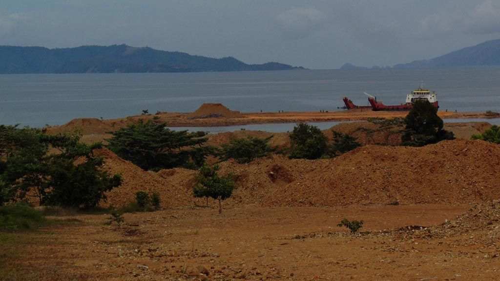 Tanah merah berisi batu atau dikenal dengan nikel ore menumpuk di dekat pesisir pantai di Kecamatan Pomalaa, Kabupaten Kolaka, Sulawesi Tenggara, Jumat (3/11). Nelayan di sekitar tambang mengeluhkan air laut yang kemerahan beberapa tahun terakhir. Mereka terpaksa melaut lebih jauh untuk mencari ikan.