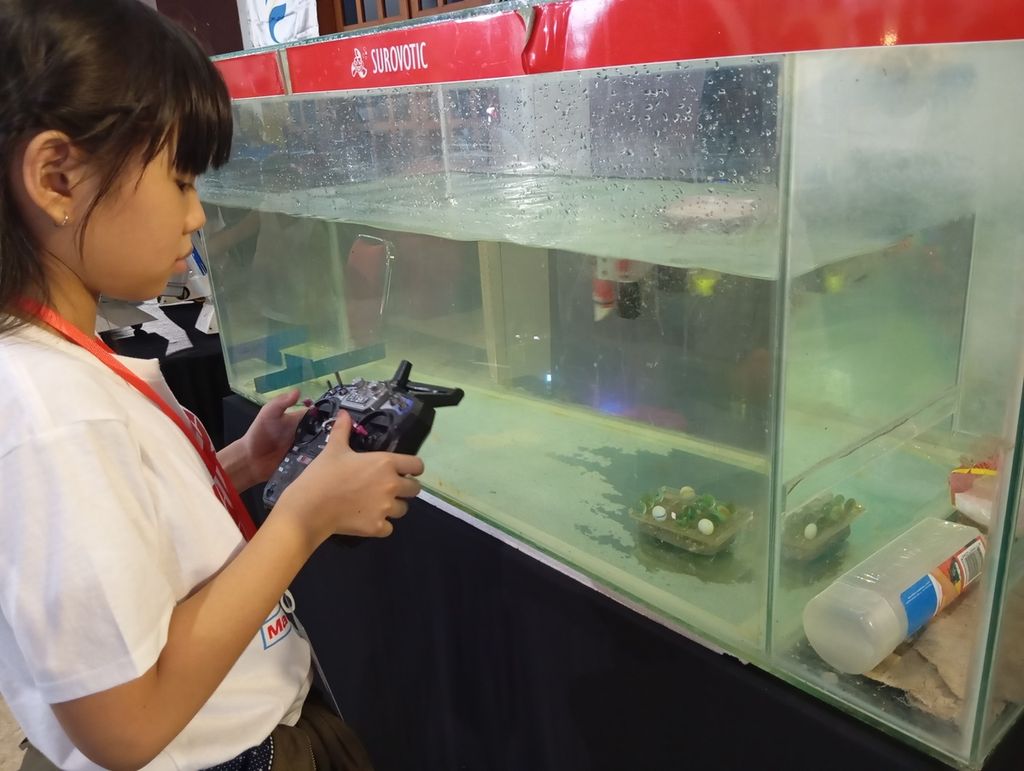 Pengunjung mengoperasikan robot survei dalam air saat Maker Faire Surabaya di Balai Pemuda, Surabaya, Jawa Timur, Sabtu (20/4/2024). 