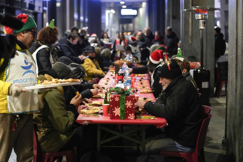 Makanan gratis dibagikan kepada para tunawisma yang hidup di jalanan oleh Yayasan Progetto Arca Onlus saat acara Natal di Milan, Italia, pada 21 Desember 2023.  