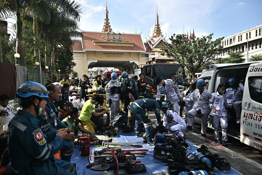 Petugas pemadam kebakaran dan penyelamat berkumpul di depan penyeberangan perbatasan Kamboja-Thailand (belakang) menyusul kebakaran besar di hotel-kasino Grand Diamond City di Poipet, Kamis (29/12/2022).