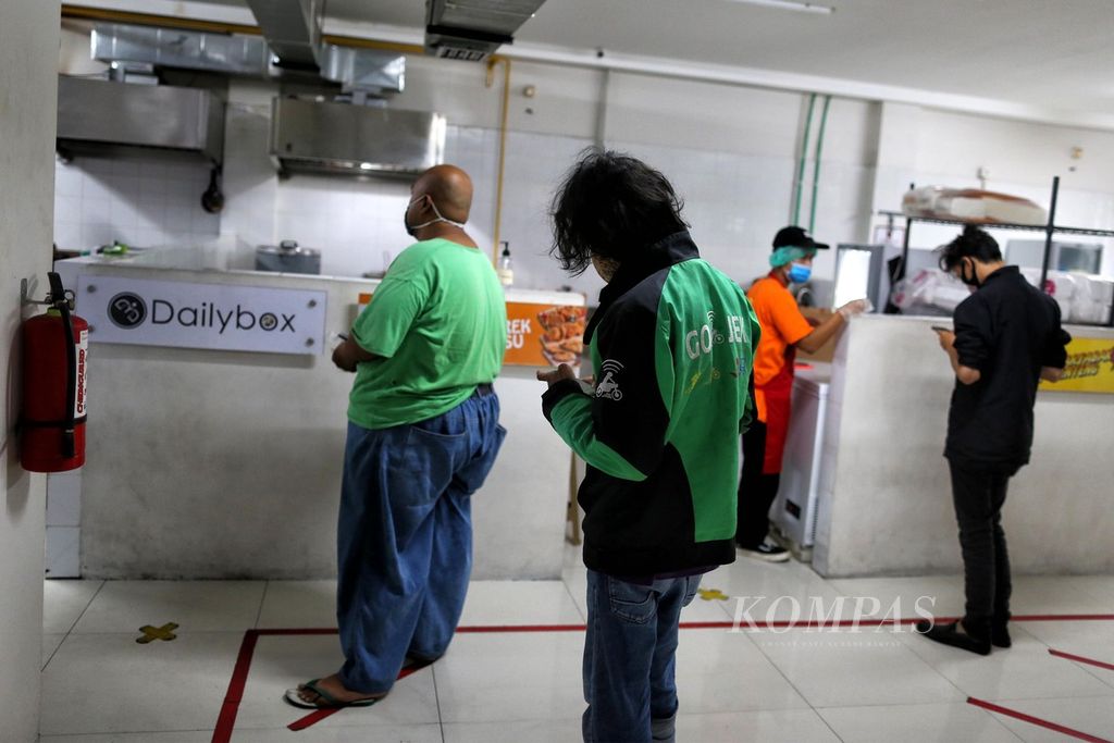Mitra pengemudi Gojek antre untuk mengambil pesanan makanan di Dapur Bersama GoFood Bintaro, Jakarta Selatan, Minggu (20/9/2020). Dapur Bersama tersebut dibuat untuk memfasilitasi UMKM kuliner agar lebih cepat berkembang.