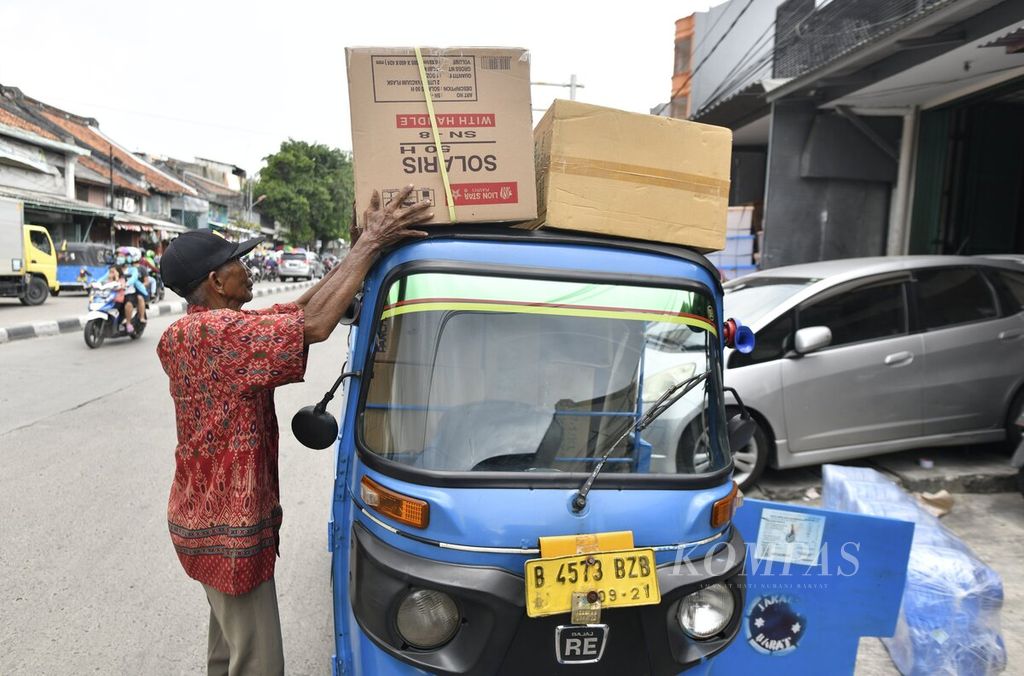 Pengemudi bajaj menata muatan di Jembatan Lima, Jakarta, 2 April 2020.