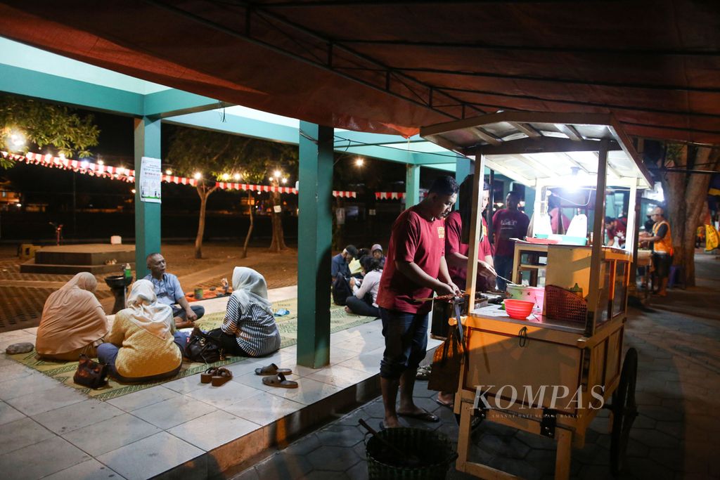 Suasana makan malam di Sate Sapi Karang Pak Prapto di Kotagede, Kota Yogyakarta, Daerah Istimewa Yogyakarta, Kamis (3/8/2023) malam. Sate sapi bumbu kacang ini disantap dengan lontong yang diberi sayur tempe. Sate Pak Prapto ini telah ada sejak tahun 1980.