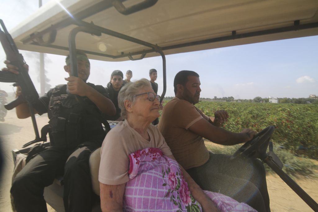  Beberapa anggota kelompok Hamas membawa seorang perempuan tua, yang merupakan warga Kibbutz Azza Kfar, ke Jalur Gaza, Sabtu (7/10/2023). Serangan Hamas pada Sabtu pagi hari itu mengejutkan militer dan intelijen Israel. 