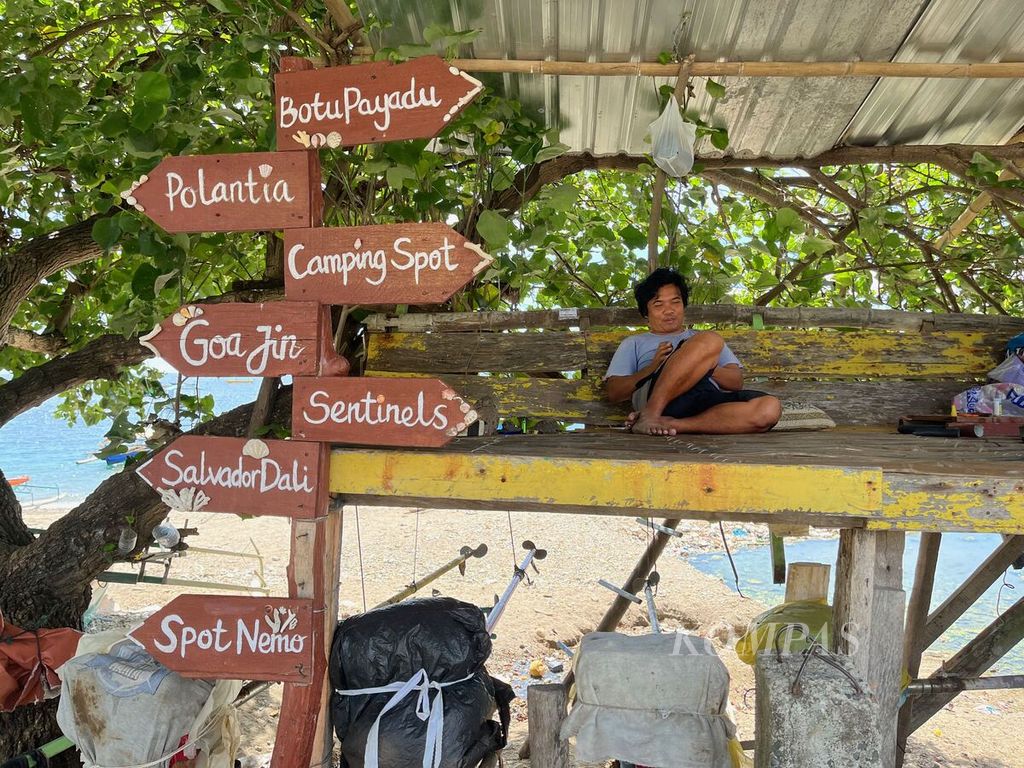 Yayan, pegiat wisata selam, sedang bersantai di tepi pantai Taman Laut Olele, Jumat (7/10/2022).