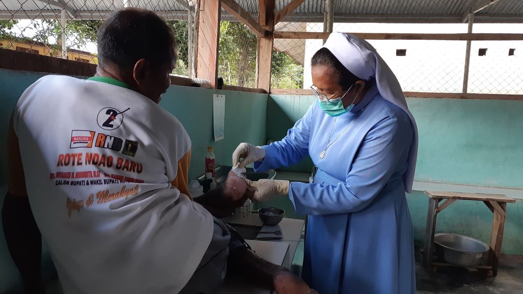 Suster Maria Verona mengobati luka kaki Lukas, pasien kusta di Rumah Sakit Kusta Pembantu Abadi, Desa Naob, Kabupaten Timor Tengah Utara, Nusa Tenggara Timur pada Oktober 2022.