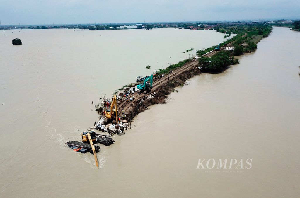 Alat berat dikerahkan untuk menutup kembali tanggul Sungai Wulan yang jebol sepanjang 35 meter hingga menyebabkan banjir beberapa hari di Kecamatan Karanganyar, Kabupaten Demak, Jawa Tengah, Senin (12/2/2024). 