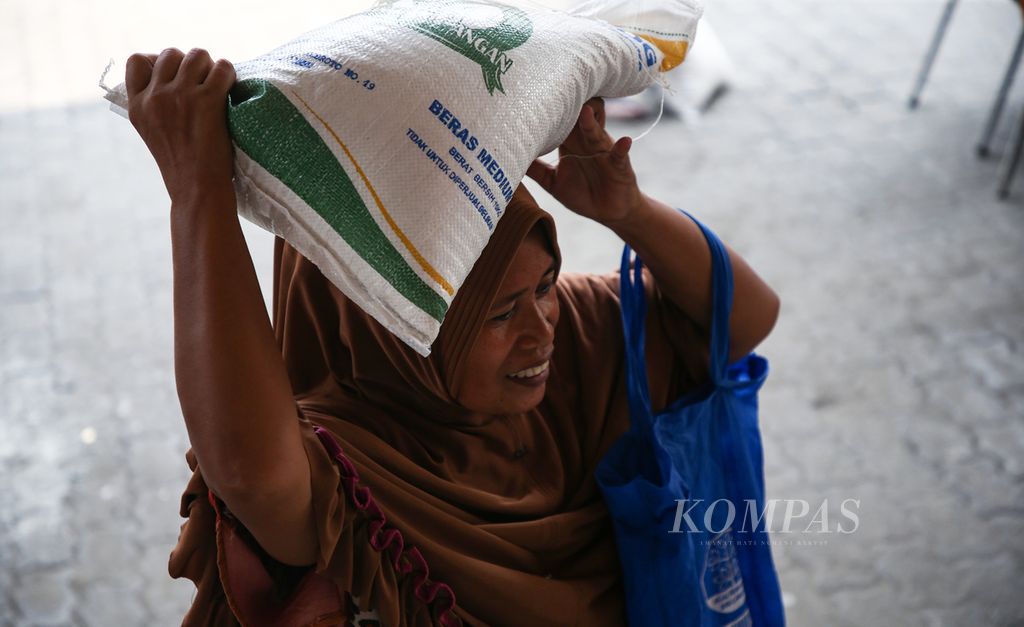 Seorang warga membawa beras yang disalurkan dalam program Bantuan Pangan Pemerintah Tahap II-2023 di Kantor Pos Tanjung Priok, Jakarta Utara, Selasa (19/9/2023). Pemerintah menggulirkan bantuan beras kepada 21,35 juta keluarga berpenghasilan rendah secara bertahap pada September-November 2023 sebanyak 640.000 ton.