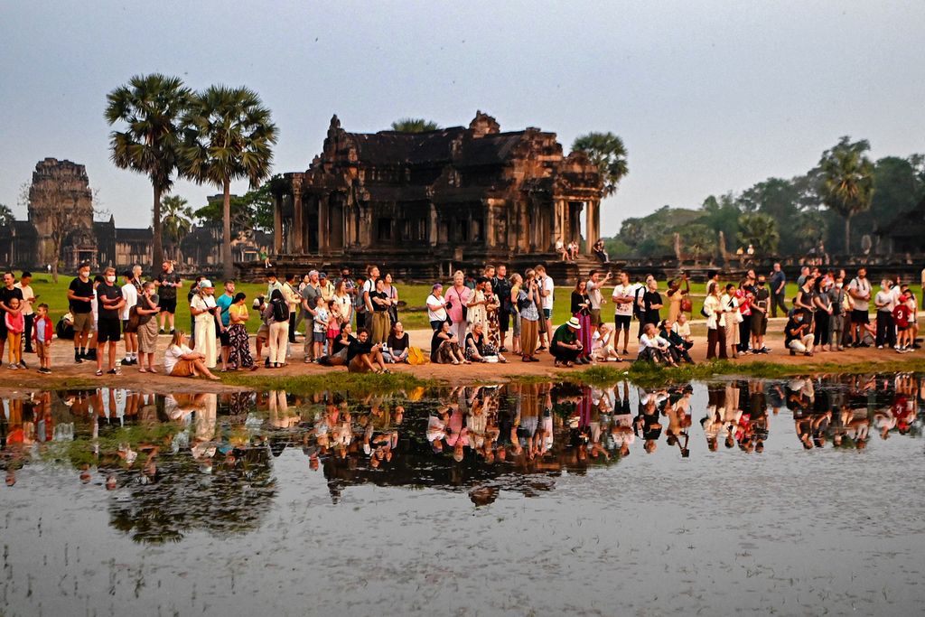 Foto yang diambil pada 8 April 2022 memperlihatkan wisatawan menikmati suasana sekitar kompleks candi Angkor Wat,Kamboja, pada pagi hari. Setelah dua tahun terakhir sepi dari pengunjung, termasuk wisatawan, kini candi yang baru menjalani sejumlah renovasi mulai bergairah kembali menerima kunjungan. 