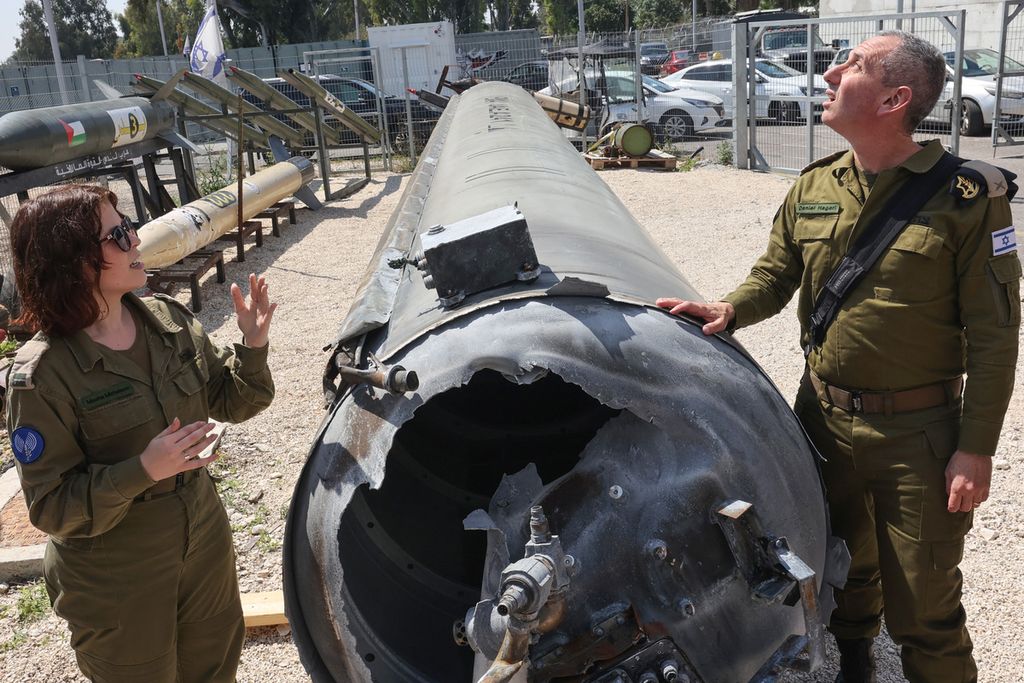 Juru bicara militer Israel, Laksamana Muda Daniel Hagari (kanan), dan wakilnya, Masha Michelson, difoto di samping rudal balistik Iran yang jatuh di Israel pada akhir pekan lalu selama tur media di pangkalan militer Julis, dekat kota Kiryat Malachi, 16 April 2024. 